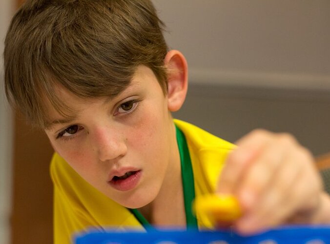 Eine Junge mit Fragiles-X-Syndrom spielt mit einem Spielzeug.